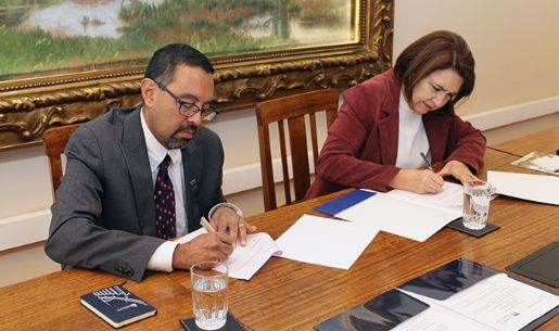 El profesor Ashutosh Bhagwat firmando el documento de acuerdo junto con la vicedecana Maricruz Gómez de la Torre.